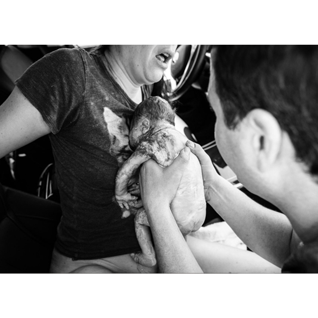 A photographer documented the birth's moments after the mother gave birth in the car.