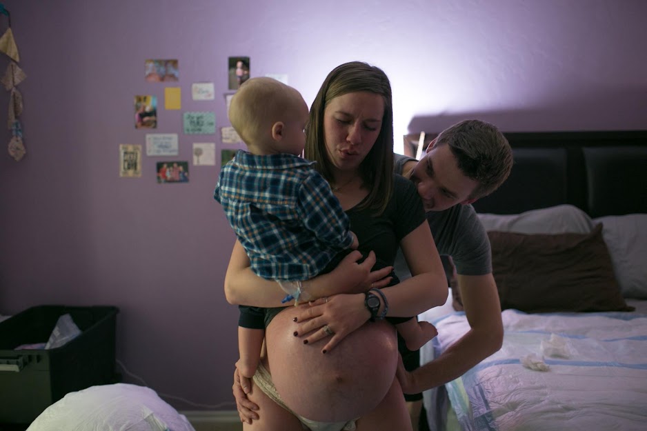 An emotional moment of a young mother welcoming twins is captured by a photographer.