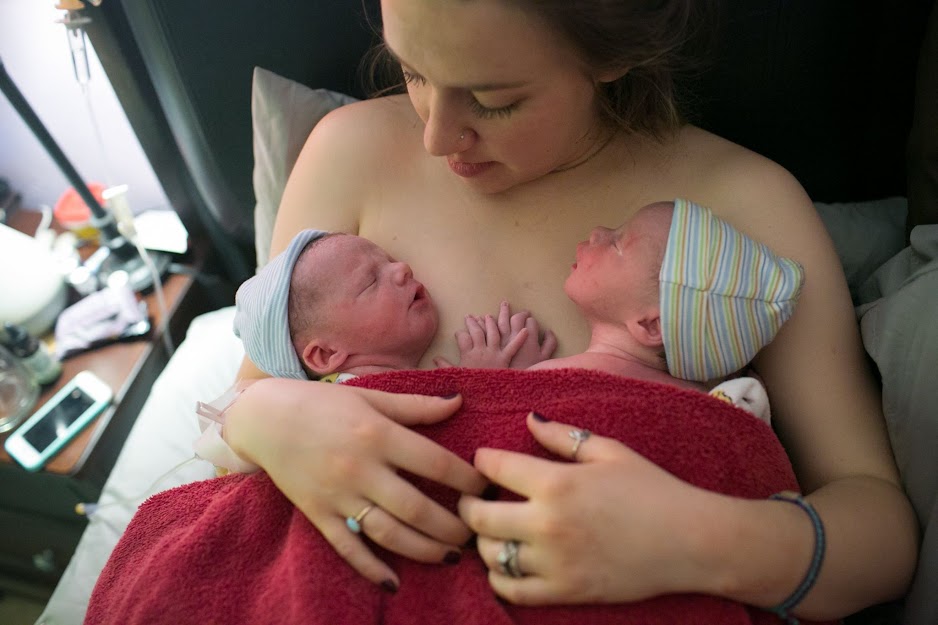 An emotional moment of a young mother welcoming twins is captured by a photographer.