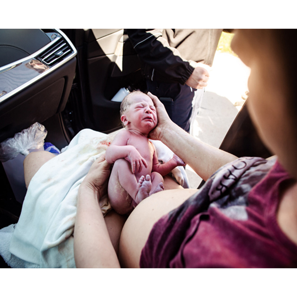 A photographer documented the birth's moments after the mother gave birth in the car.