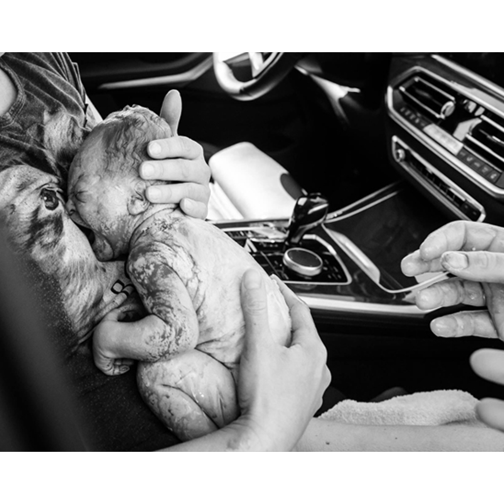 A photographer documented the birth's moments after the mother gave birth in the car.