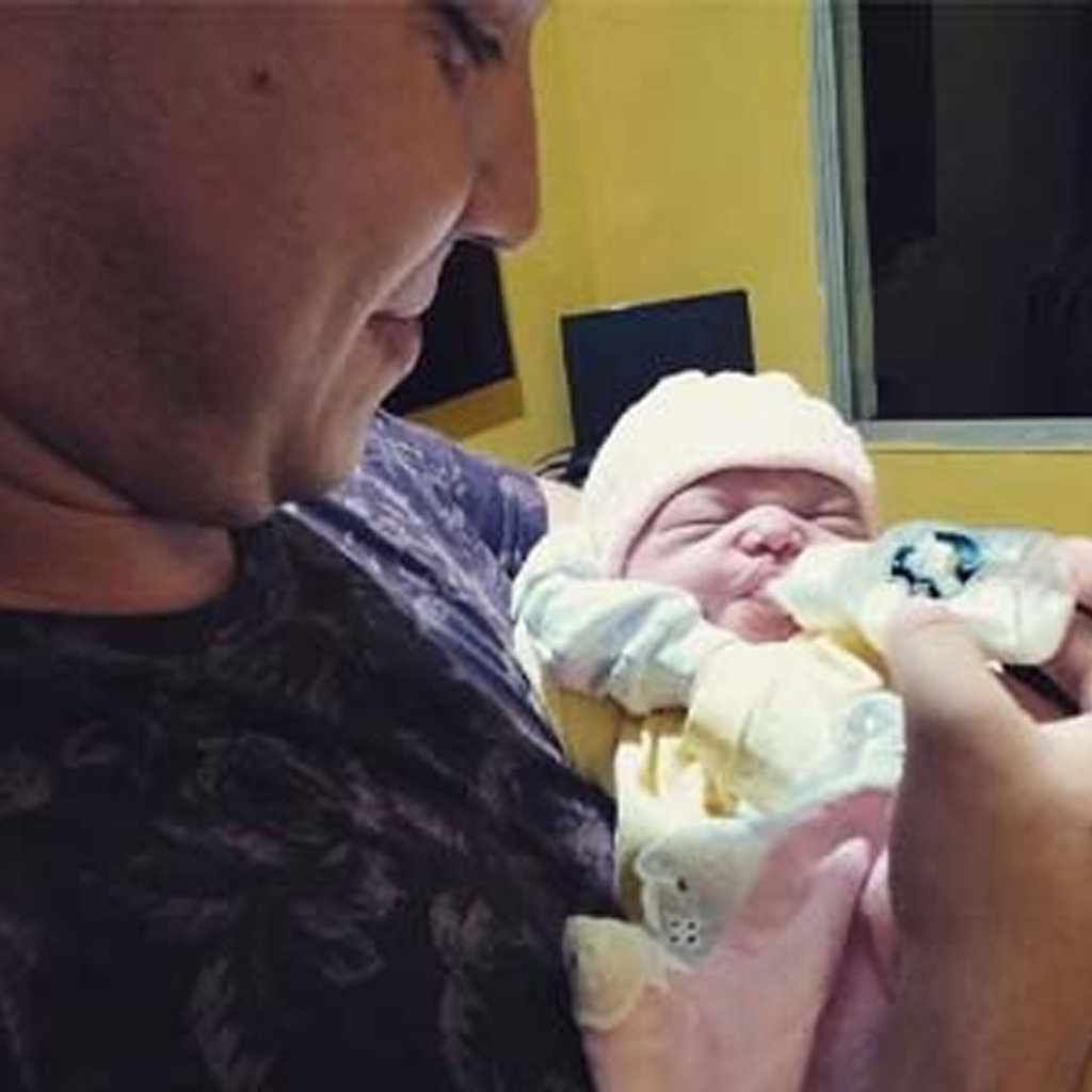 As the baby is born, she responds to her father's voice with a huge grin after having spent months l