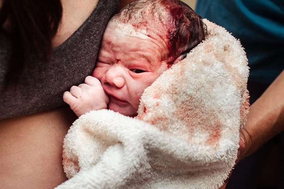 A woman gives birth unexpectedly while traveling to the birth center in a car.